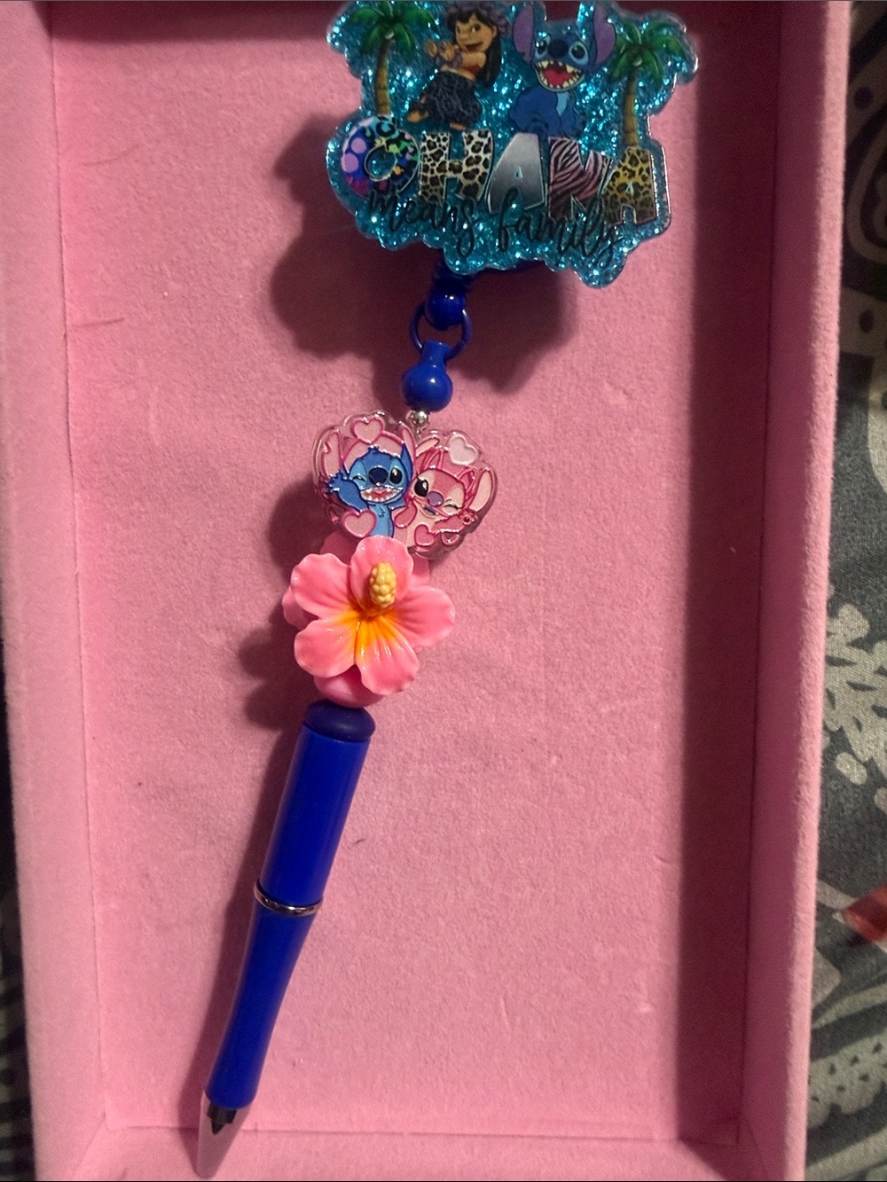 Blue badge reel with retractable pen.